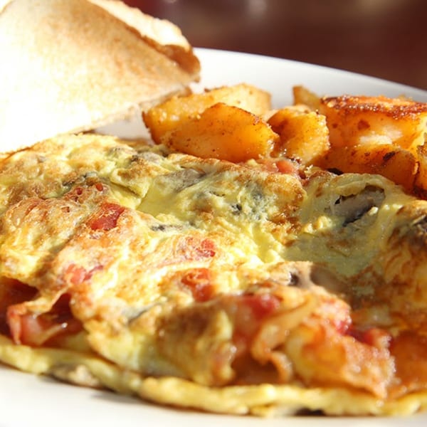 A Dempsey's omelet filled with bacon and mushrooms, served with crispy home fries and toast.
